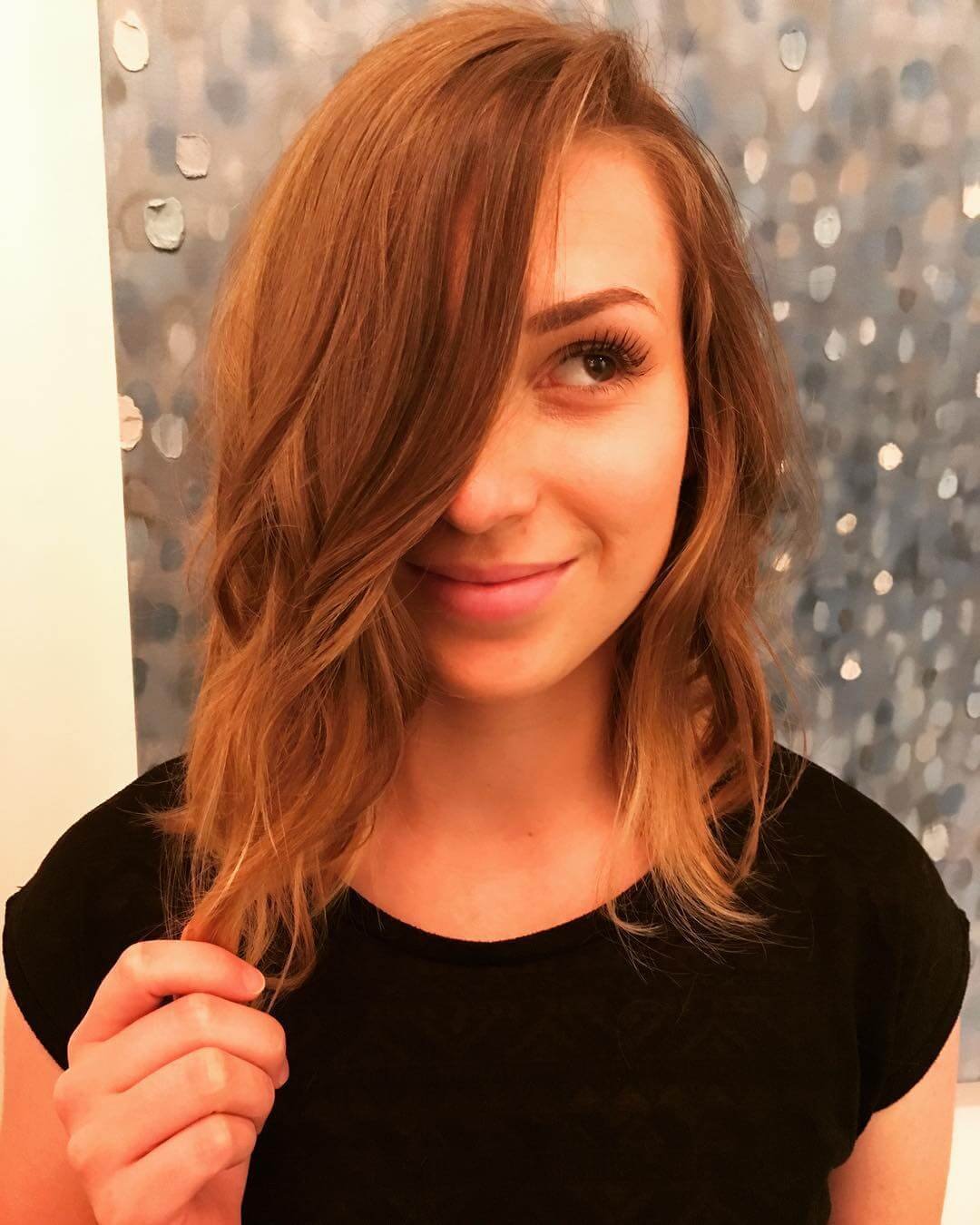 An angled choppy bob haircut with shorter hair at the back and longer hair towards the front, featuring choppy layers for a textured and trendy appearance