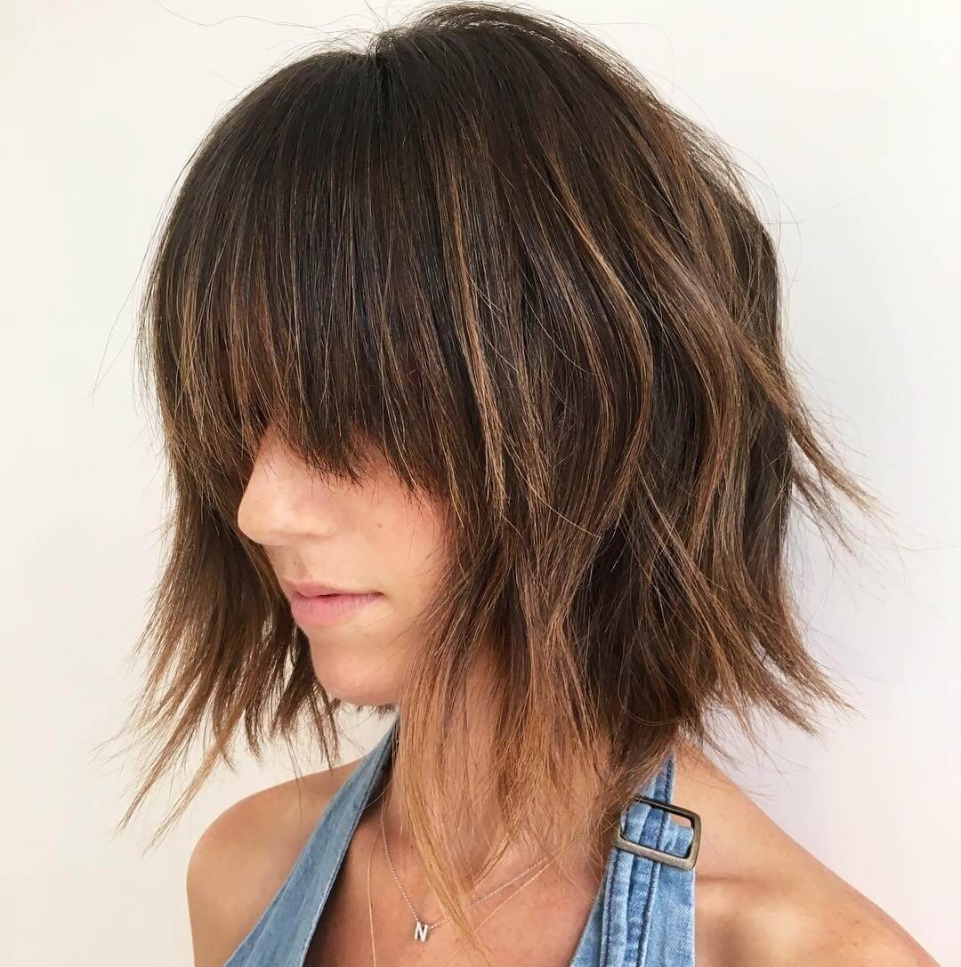 Short to medium-length choppy bob with textured layers and blunt-cut bangs for a sophisticated style