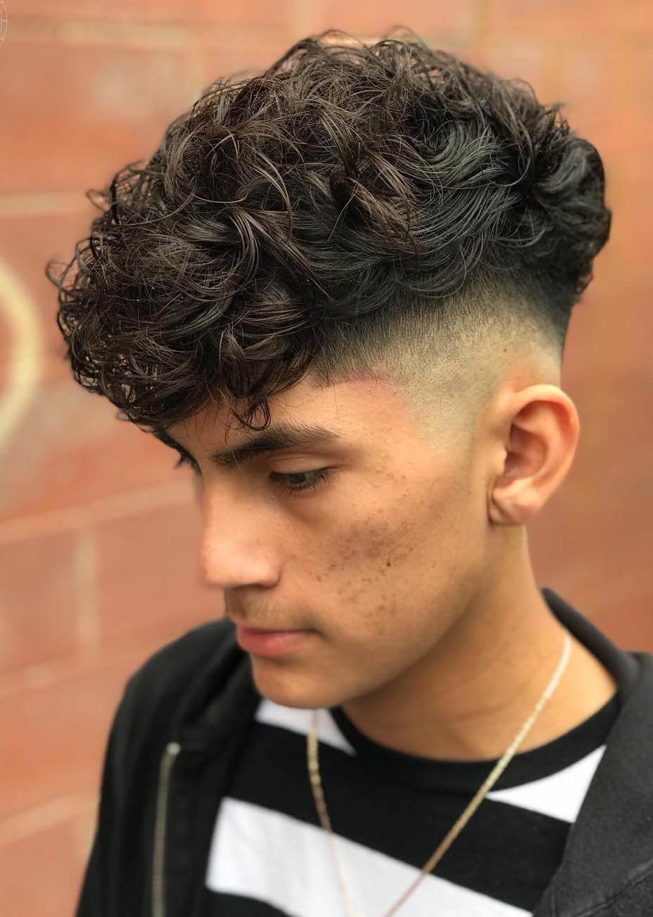 High platform haircut with shaved sides and a voluminous top, adding height and drama to the style
